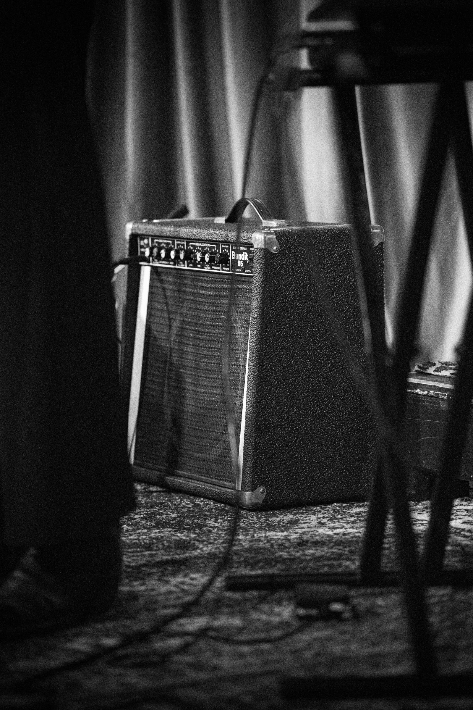 A guitar amp cabinet shot close, grille cloth and corner visible