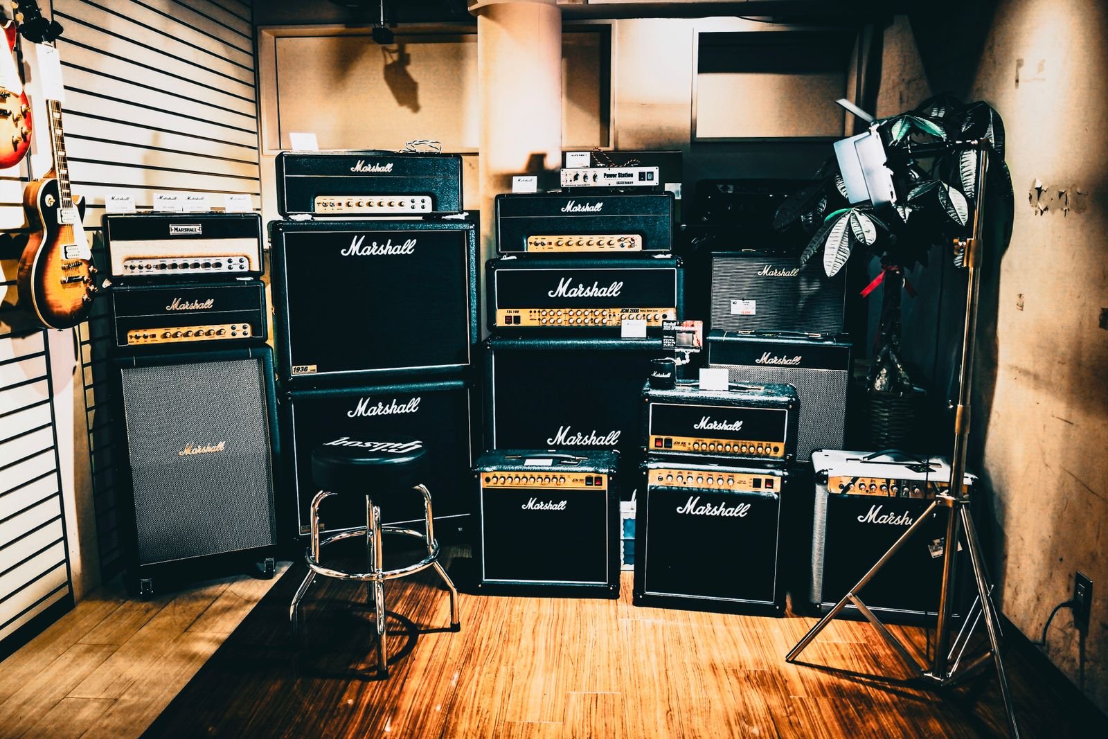 A towering Marshall-style amplifier stack lit on a dark stage
